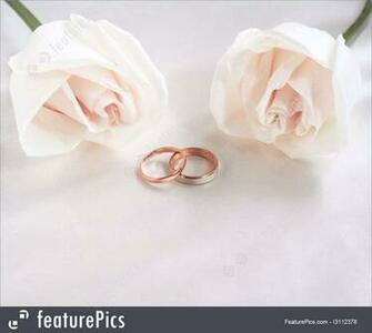 Wedding Rings And Roses As Background