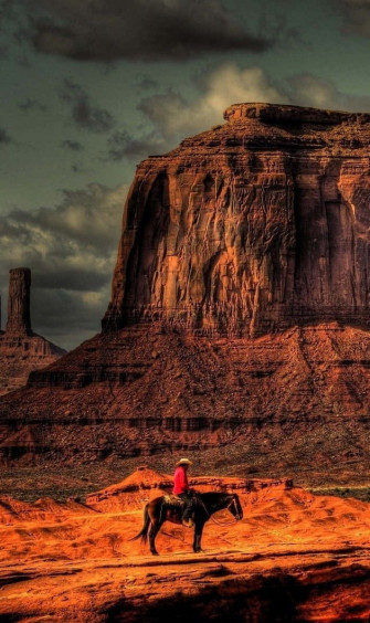A Cowboy Riding Horse In Monument Valley Wallpaper