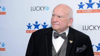Legendary Actor Edward Asner Against A Blue And White Wallpaper
