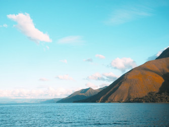 A Body Of Water With Mountains In The Background Photo Blue