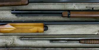Firearms Hanging On Rustic Wooden Background