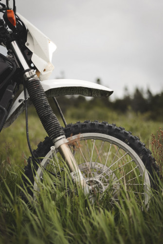 White And Black Motorcycle On Green Grass Field During Daytime