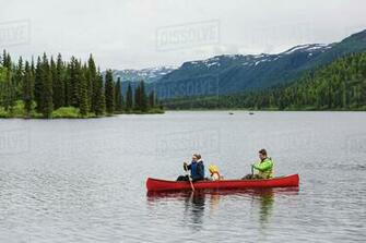Family In Red Canoe On Byers Lake With Green Tree Covered Hills