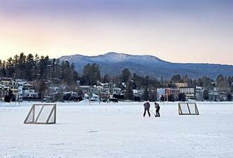 Kids Playing Hockey On Mirror Lake With Placid Village Shown