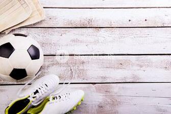 Soccer Ball Cleats Against Wooden Floor Studio Shot On White