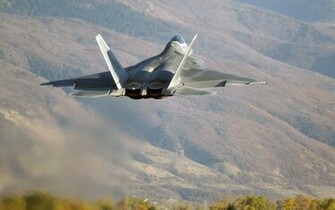 F22 Over Hills Wallpaper Stock Photos