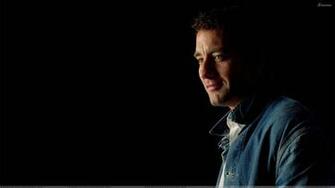 Clive Owen Smiling Side Pose N Black Background Wallpaper