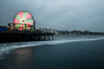 Big Colorful Ferris Wheel And A Rollercoaster At The Santa Monica Pier On Wallpaper