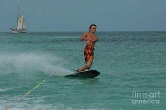 Young Guy Wakeboarding With A Ship In The Background