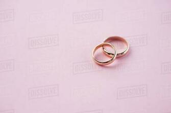Close Up Of Shiny Golden Wedding Rings On Pink