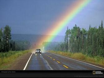 The End Of A Rainbow Spotlights Solitary Car Traveling Down