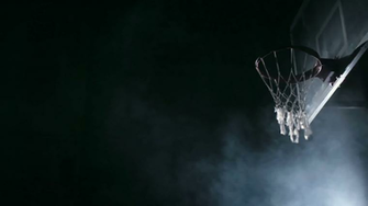 One Handed Slam Dunk Performed By Basketball Player In Dark Court