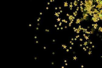 Scattering Of Yellow Coloured Glitter Star Shapes On A Black Backdrop