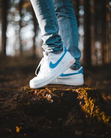 Person Wearing Blue Denim Jeans And White Nike Air Max Shoes