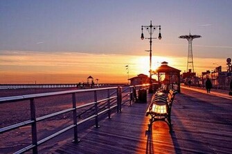 Coney Island Boardwalk At Sunset With Parachute Jump In The Background