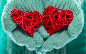 Red Hearts In Hand With Blue Mittens Winter Love Background