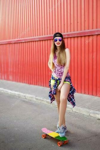 Girl With A Skateboard On Background Of Red Wall Stock Photo