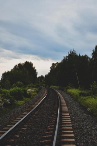 Train Rail Near Green Trees Under Cloudy Sky During Daytime Photo
