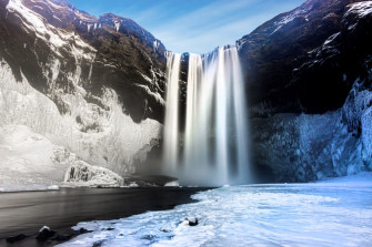Waterfalls On Rocky Mountain Under Blue Sky During Daytime Photo