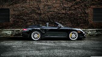 Black Porsche Turbo S Cabriolet By A Brick Wall