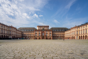 A Large Building With Clock On The Front Of It Photo