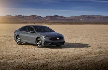 Silver Car Volkswagen Jetta On The Background Of Mountains Under