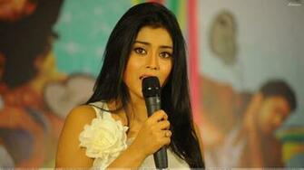Shriya Saran On Stage Mic In Hand At Nuvva Nena Press Meet Wallpaper