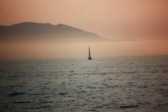 Dusky Pink Sunset With Sailboat And Mountain Background Photograph