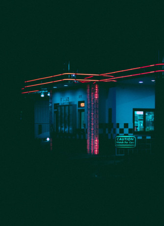 A Gas Station Lit Up At Night With Neon Lights Photo