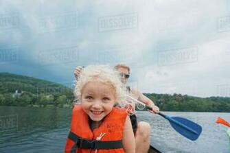 Happy Daughter In Canoe With Father Canoeing Background Against