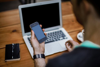 Wallpaper Id A Man Holding An iPhone While Sitting At