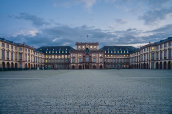 A Large Building With Clock Tower In The Middle Of It Photo