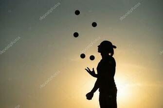 Silhouette Of A Man Juggling With Balls At Sunset Stock Photo