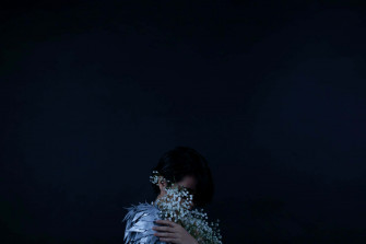 Timid Person Holding Flowers Dark Wallpaper
