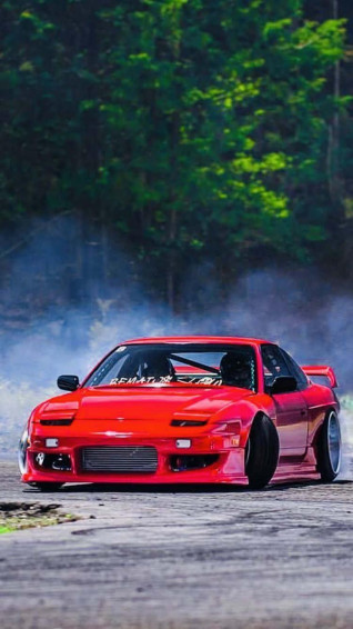 A Red Drift Car Driving Down Track Wallpaper