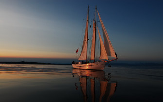 Serene Sailboat At Sunset Wallpaper