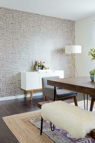 A Dining Room With Wallpaper Accent Wall And Layered Rugs