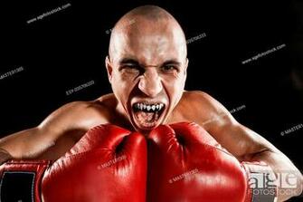 The Young Male Athlete Kickboxing On A Black Background With Kapa